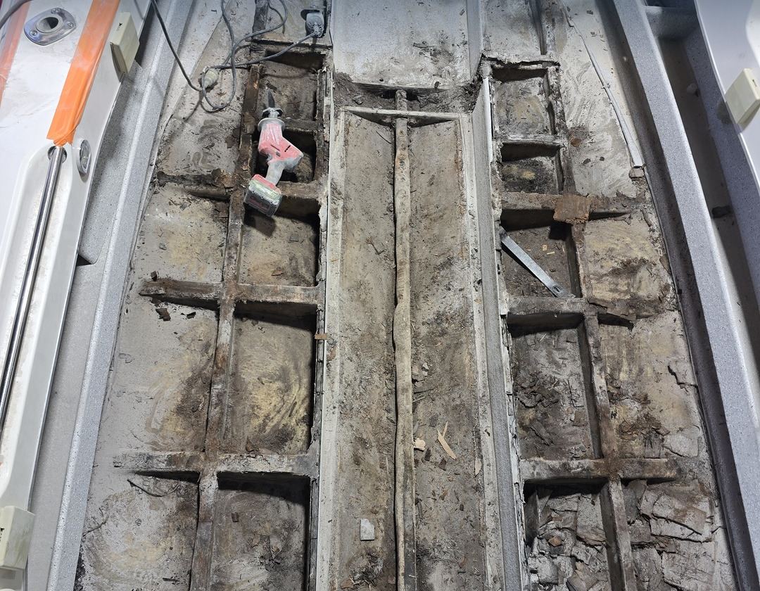 Floor lifted on a trailer boat in our workshop: the stringers and core underneath had rotted out.
